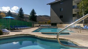 Ein Poolbereich mit mehreren Liegestühlen und einem Pool mit einer gefliesten Kante.