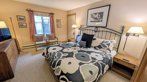 A bedroom with a bed, two chairs, a desk, a lamp, and a picture on the wall. - Spacious Condo w/ FREE WiFi, Parking, Heated Pool, Hot Tubs, Skier Shuttles (Avon)