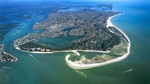 An aerial view of a coastal city with a dense urban area, a large bay, and a curved coastline. - 5-Min Walk to Beach! Private Heated Pool & 5BR Home (Marco Island)