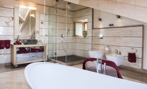 Een bad/douchecombinatie, een haardroger, een bidet, handdoeken