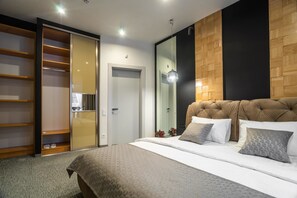 A modern bedroom with a large bed, a wardrobe with sliding doors, and a mirror on the wall.