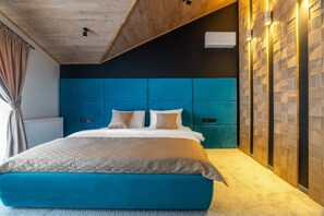 A modern bedroom with a large bed, a wooden ceiling, and a wall with a geometric pattern. - Greitser Elit Chalet (Bukovel)