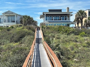 A wooden boardwalk leading to a beachfront property with a modern house and a large balcony. -  Beachfront/heated pool/spa. Ocean Views! Last minute promotion available! (St Augustine)