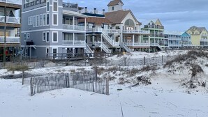 Una propiedad frente a la playa con edificios de varios pisos, balcones y una escalera destacada.