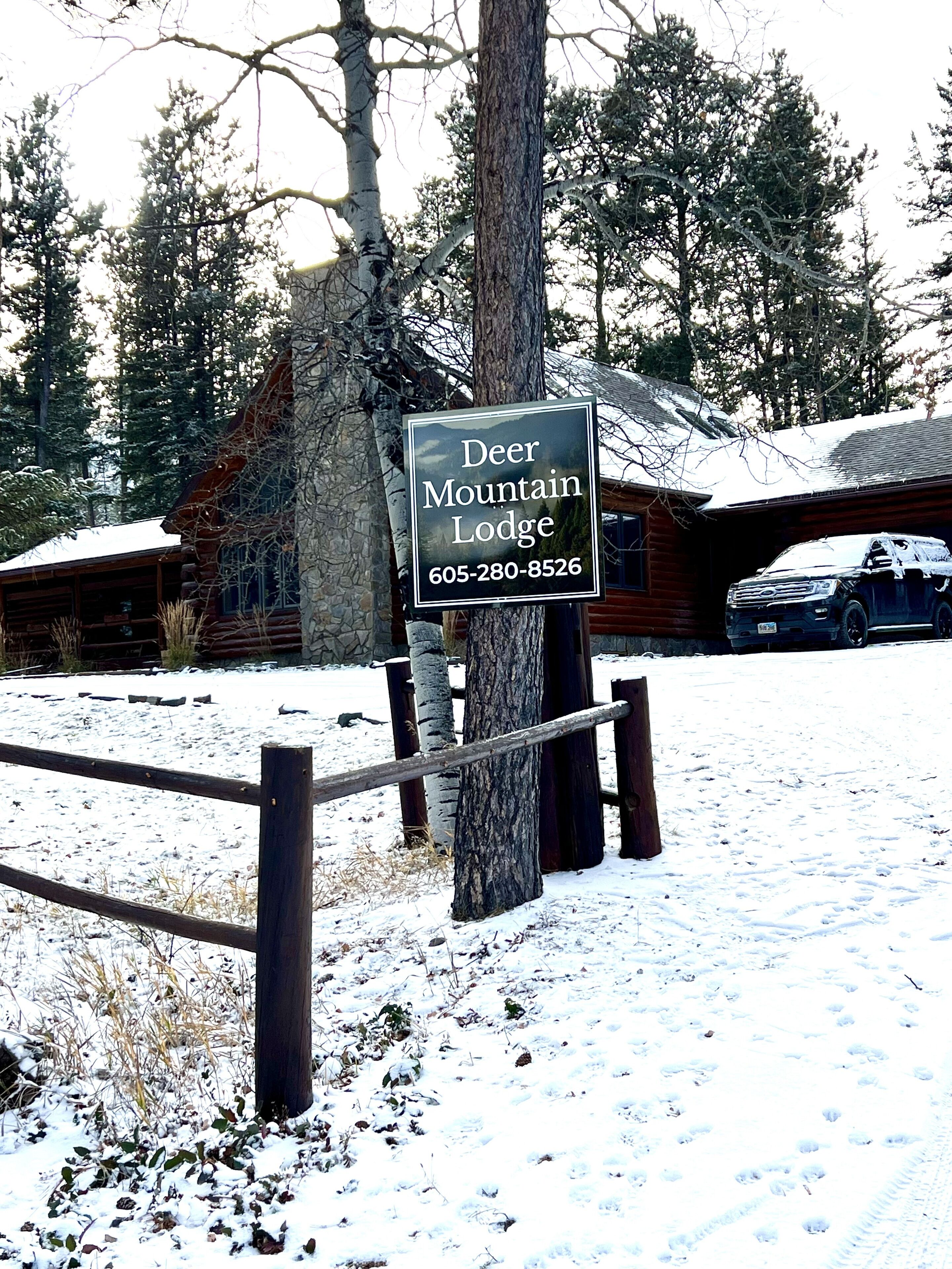 Une enseigne indiquant le Deer Mountain Lodge, avec un numéro de téléphone à contacter.