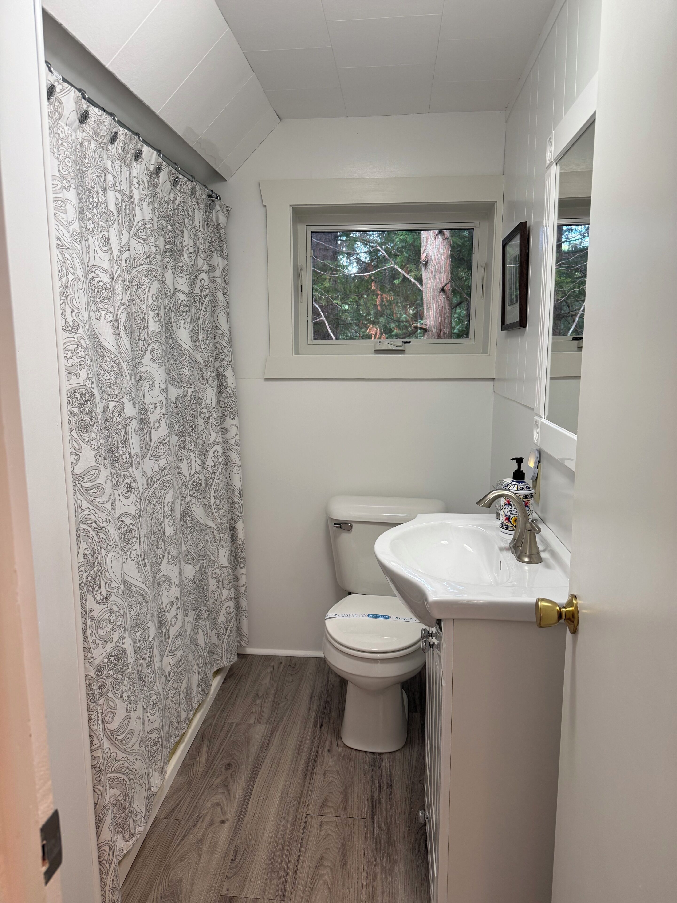 Et badeværelse med toilet, vask og vindue.