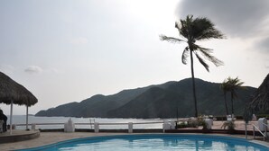 Ein Poolbereich mit Blick auf das Meer und die Berge.