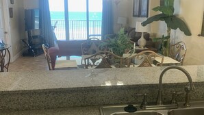 Una cocina con encimeras de granito, pileta de acero inoxidable y ventilador de techo.