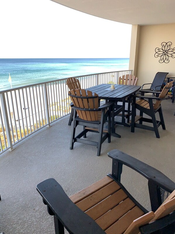 A covered outdoor seating area with a view of the ocean.