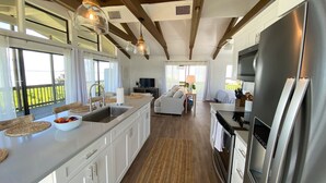 A spacious kitchen with a large island, stainless steel appliances, and a dining area with a TV. - North Captiva Point House - Boat/Water Taxi Only **NEWLY RENOVATED ** (North Captiva)