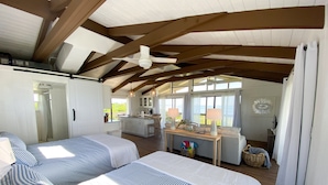 A bedroom with two beds, a kitchenette, and a view of the outdoors. - North Captiva Point House - Boat/Water Taxi Only **NEWLY RENOVATED ** (North Captiva)
