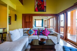 A living room with a sofa, a coffee table, and a painting on the wall.
