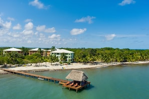 A resort with overwater bungalows, a beach, and a pier.