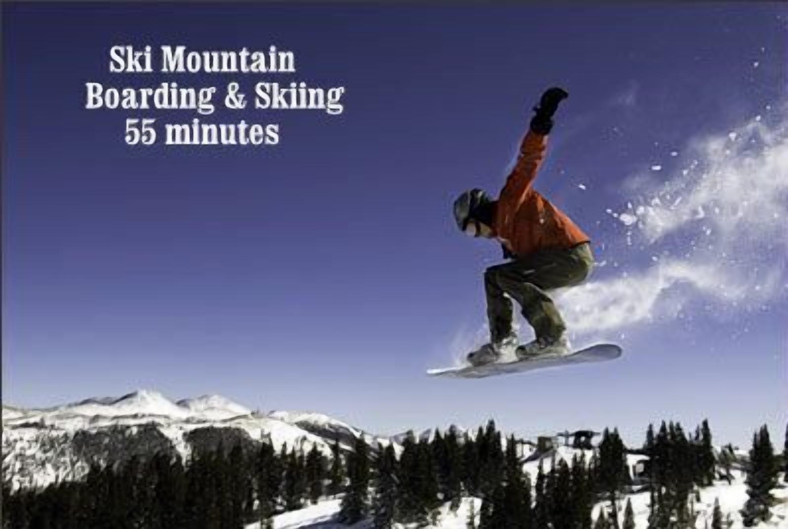 Un snowboardeur en plein saut, avec une chaîne de montagnes en arrière-plan.