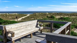 A wooden bench on a wooden deck overlooking a beach with dunes and a clear sky. - Beautiful First Floor Oceanfront Condo at Amelia Surf and Racquet-Close to Pool! (Fernandina Beach)