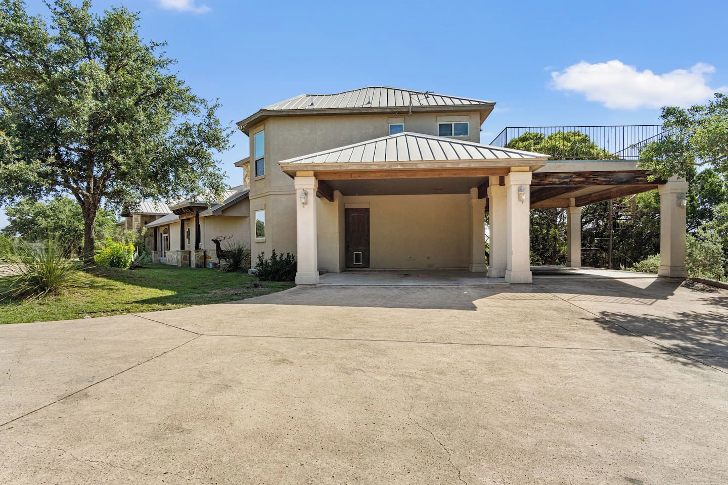 A two-story building with a covered entrance and a driveway leading to the main entrance.