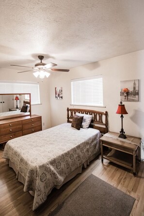 A bedroom with a bed, dresser, nightstand, and a ceiling fan. - Casa Rio River House @ Casa Rio Rentals- River Front, Pet Friendly in Concan (Concan)