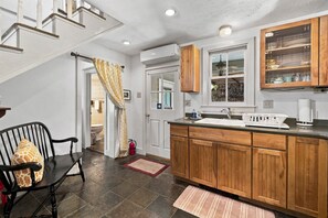 A kitchen with wooden cabinets, a sink, and a window with a view.