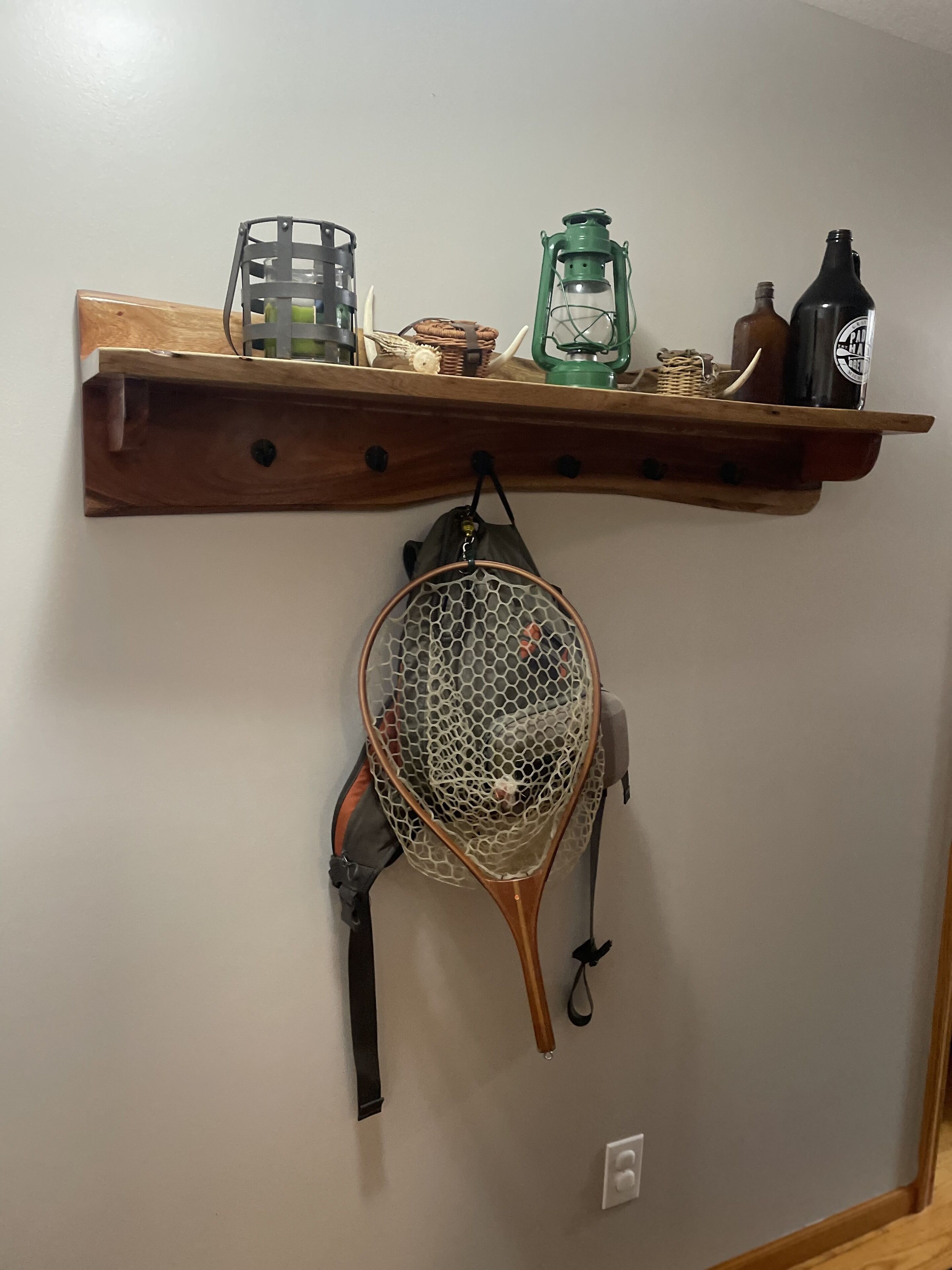 A wooden shelf with a lantern, a bottle, and a net.