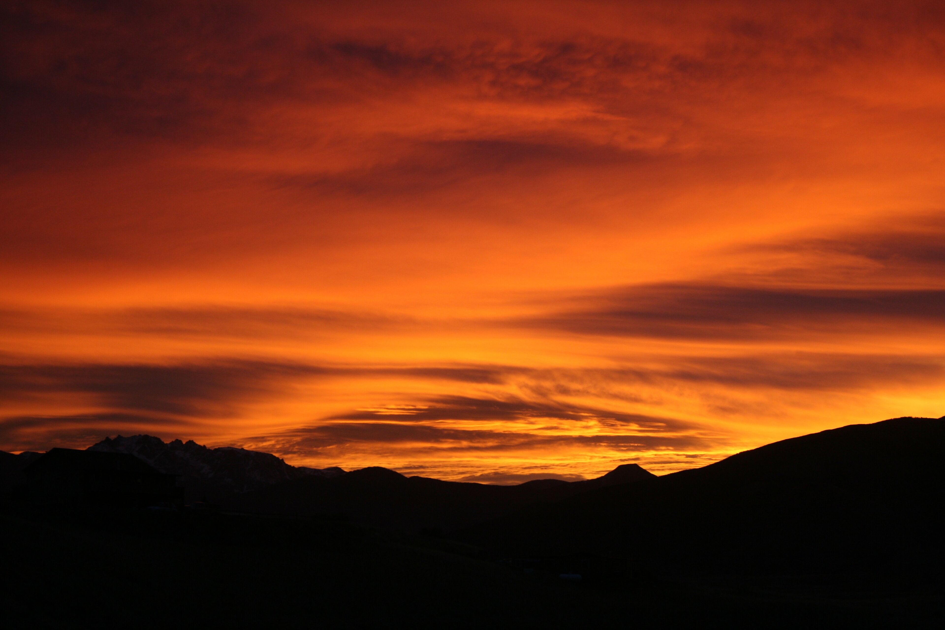 La silhouette d’une chaîne de montagnes se détachant sur le ciel au coucher du soleil.