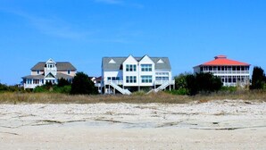 A beachfront property with multiple houses, including a large white house with a red roof and a smaller house with a grey roof. - RARE 6 bedroom, 4 bath OCEANFRONT home, wonderful views & breathtaking sunsets! (Edisto Beach)