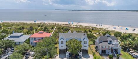 A coastal residential area with houses, a beach, and a view of the ocean.