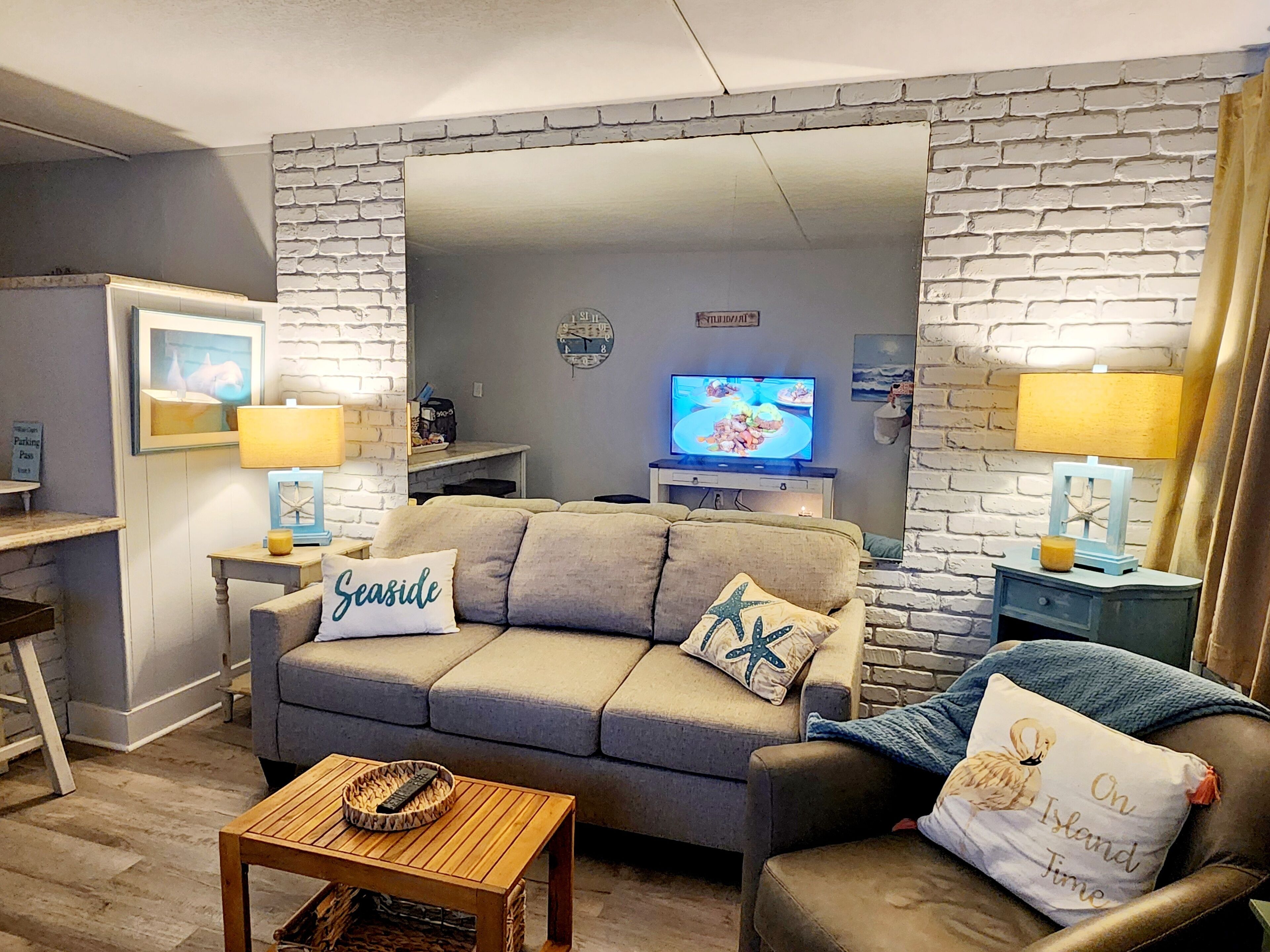 A living room with a grey sofa, a wooden coffee table, and a television on a stand.