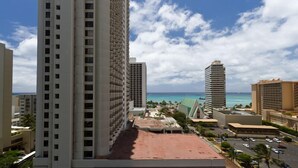 A high-rise hotel with a view of the ocean and a clear sky. - Upgraded 1BR Condo Ocean View - Kitchen, FREE parking, WiFi (Honolulu)