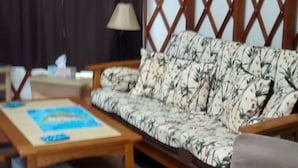 Une pièce avec un canapé, une table basse et une lampe.
