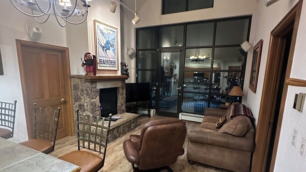 Un vaste espace de vie doté d’un haut plafond, d’une cheminée, d’une table à manger et d’un coin salon confortable.