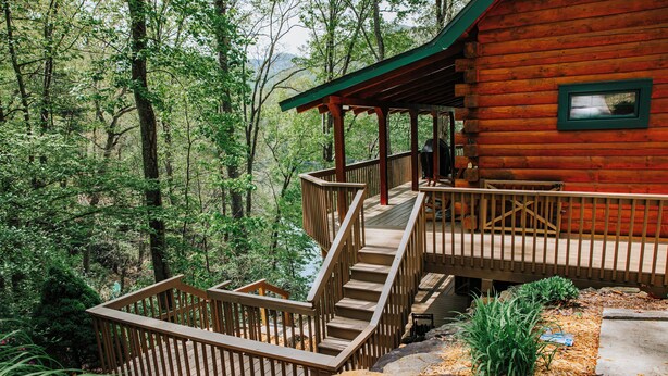 A wooden cabin with a deck and stairs leading to a covered porch. - Serenity on Cedar-Lakefront Cabin- 10 boats-Swim/Fish/Boat, Starlink & Hulu Live (Tuckasegee)