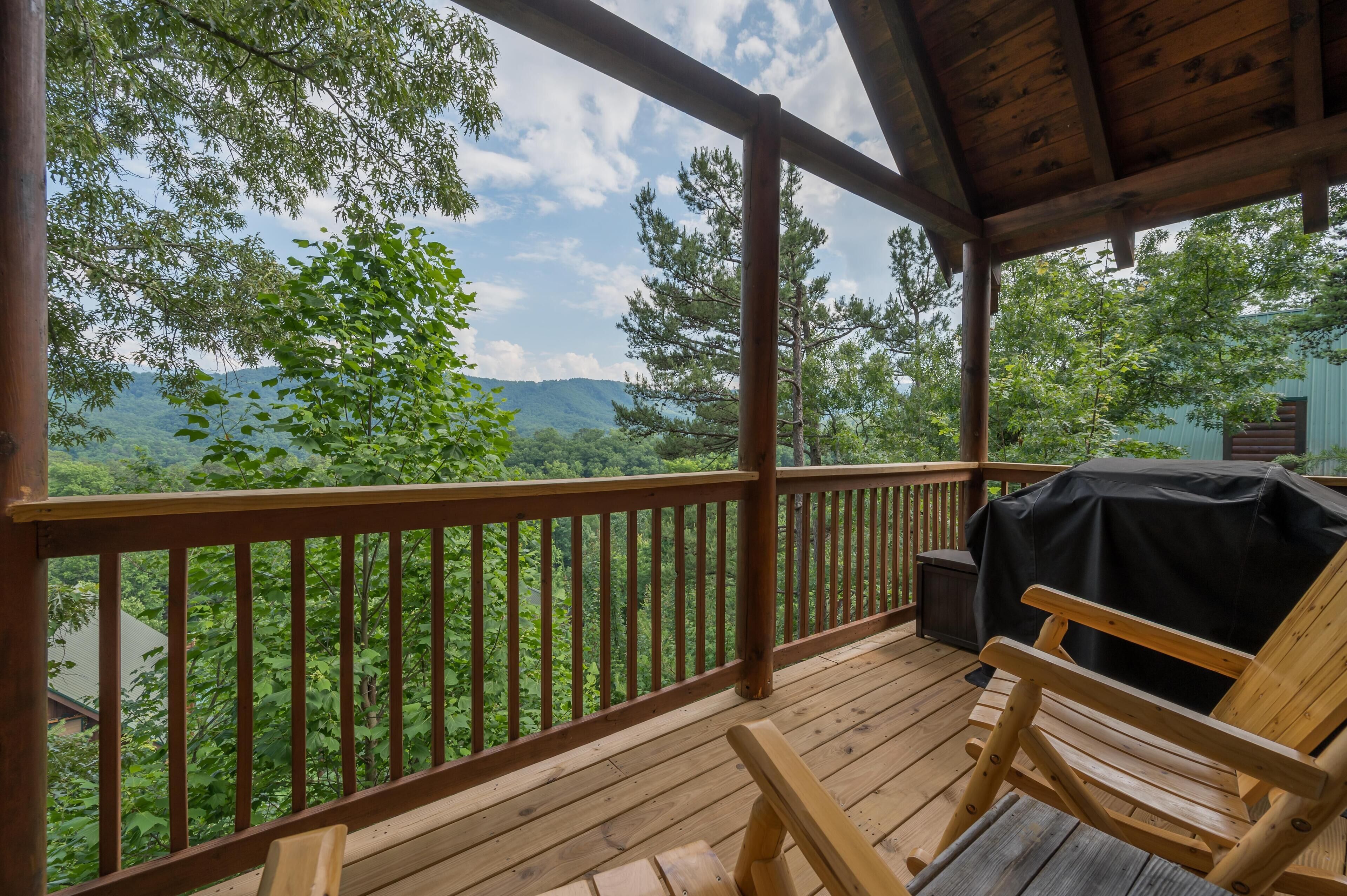 Une terrasse en bois offrant une vue sur un paysage montagneux.