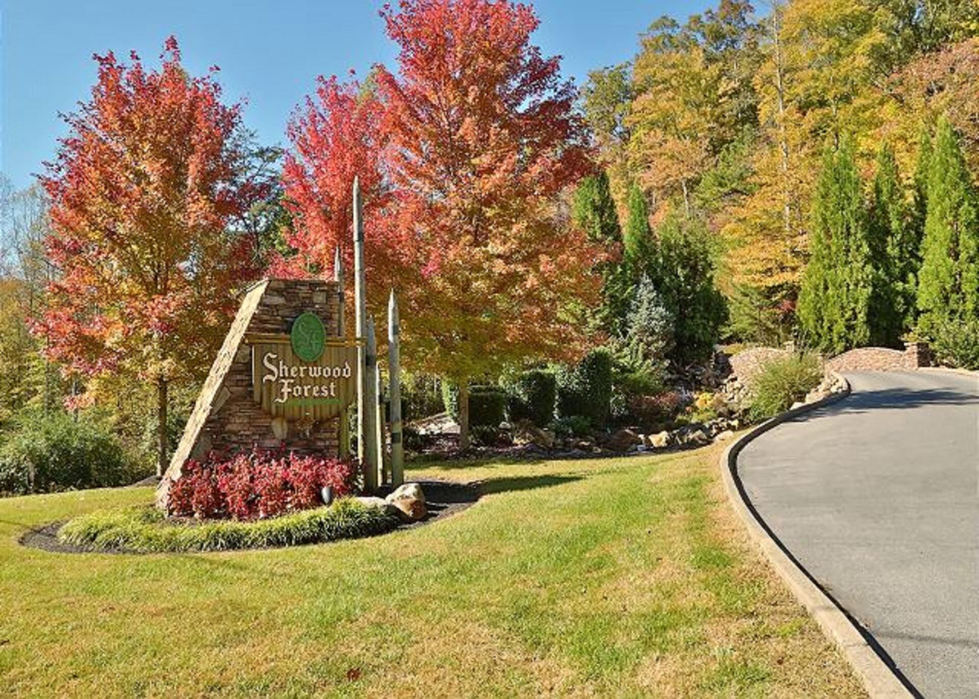A sign for Sherwood Forest with a curved road and autumn foliage.