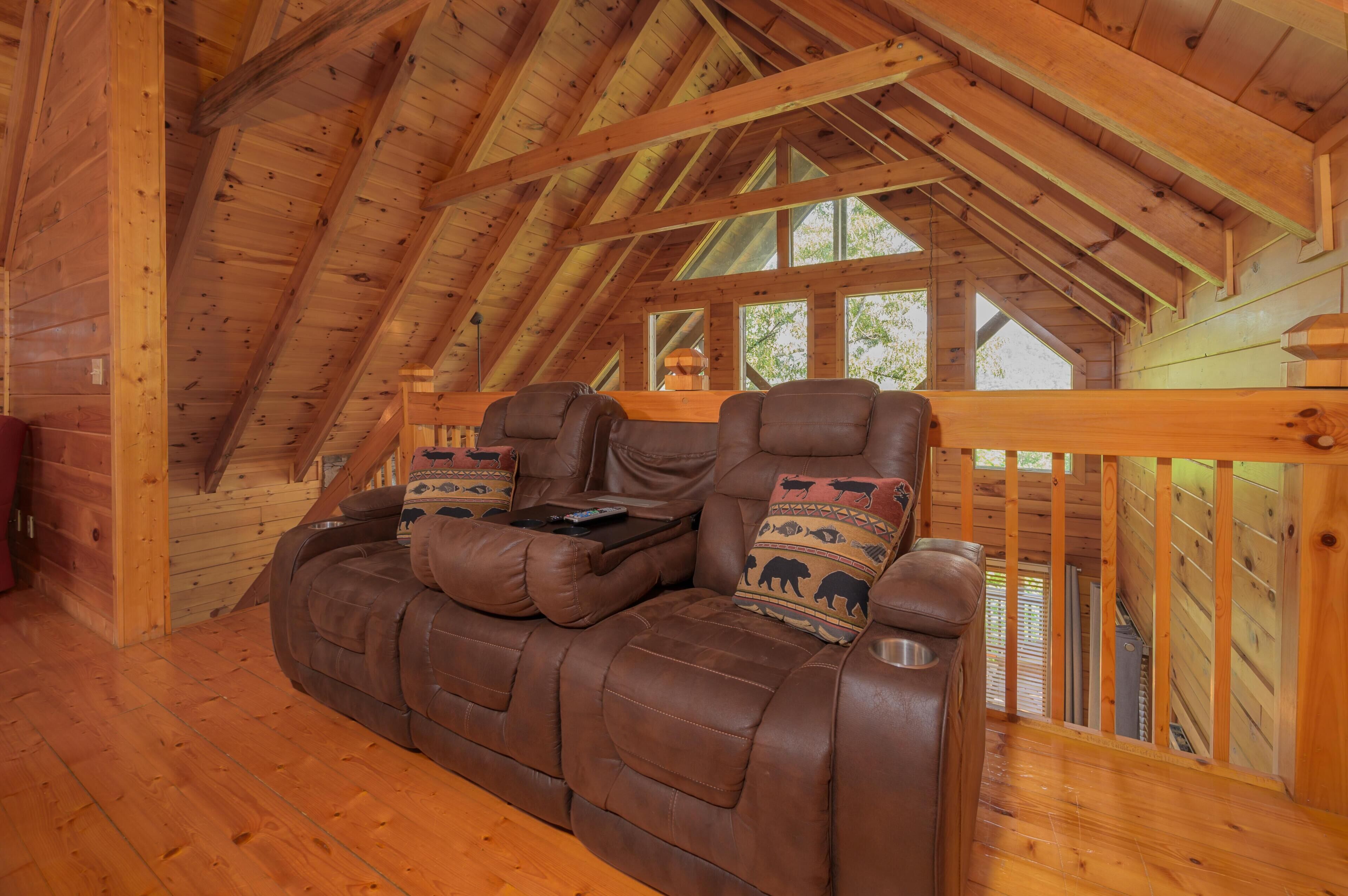 A wooden interior with a high ceiling and a sofa with animal-themed cushions.