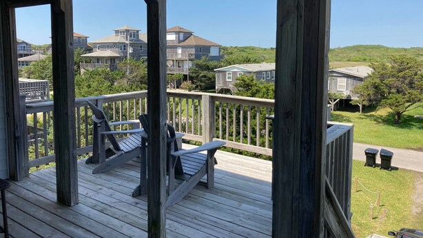 A wooden deck with a railing, a bench, and two trash bins. - Frisco Beach House! Some ocean views! Easy walk to the beach!  (Frisco)