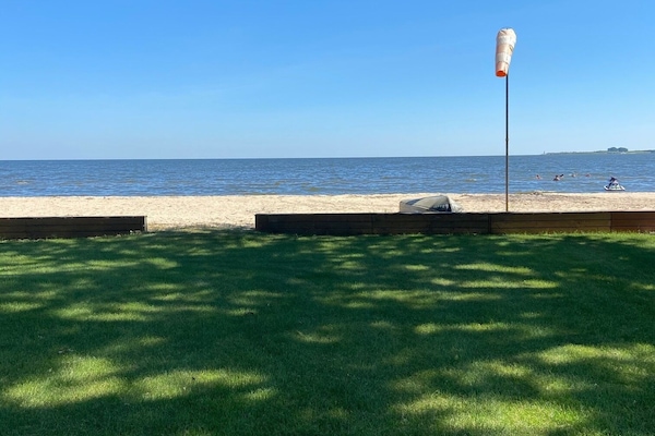 view from deck. lawn leading to private beach
