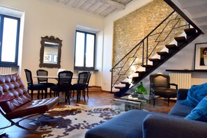 A spacious living room with a modern staircase, leather furniture, and a stone wall. - Historic Center of Spoleto/Terrace with Fantastic Views/Car Unneccesary  (Spoleto)