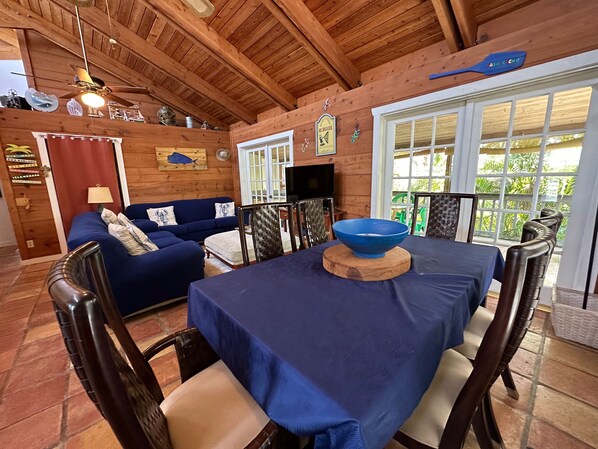 Un interior de madera con una mesa de comedor, sillas, un sofá y un ventilador de techo.