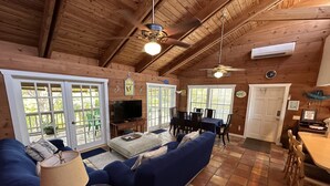 A cozy cabin interior with a living room, dining area, and kitchen.