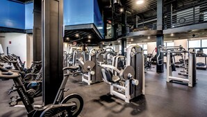 Ett gym med olika typer av träningsutrustning, inklusive löpband och styrketräningsmaskiner.