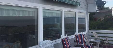 A deck with rocking chairs and a covered area.
