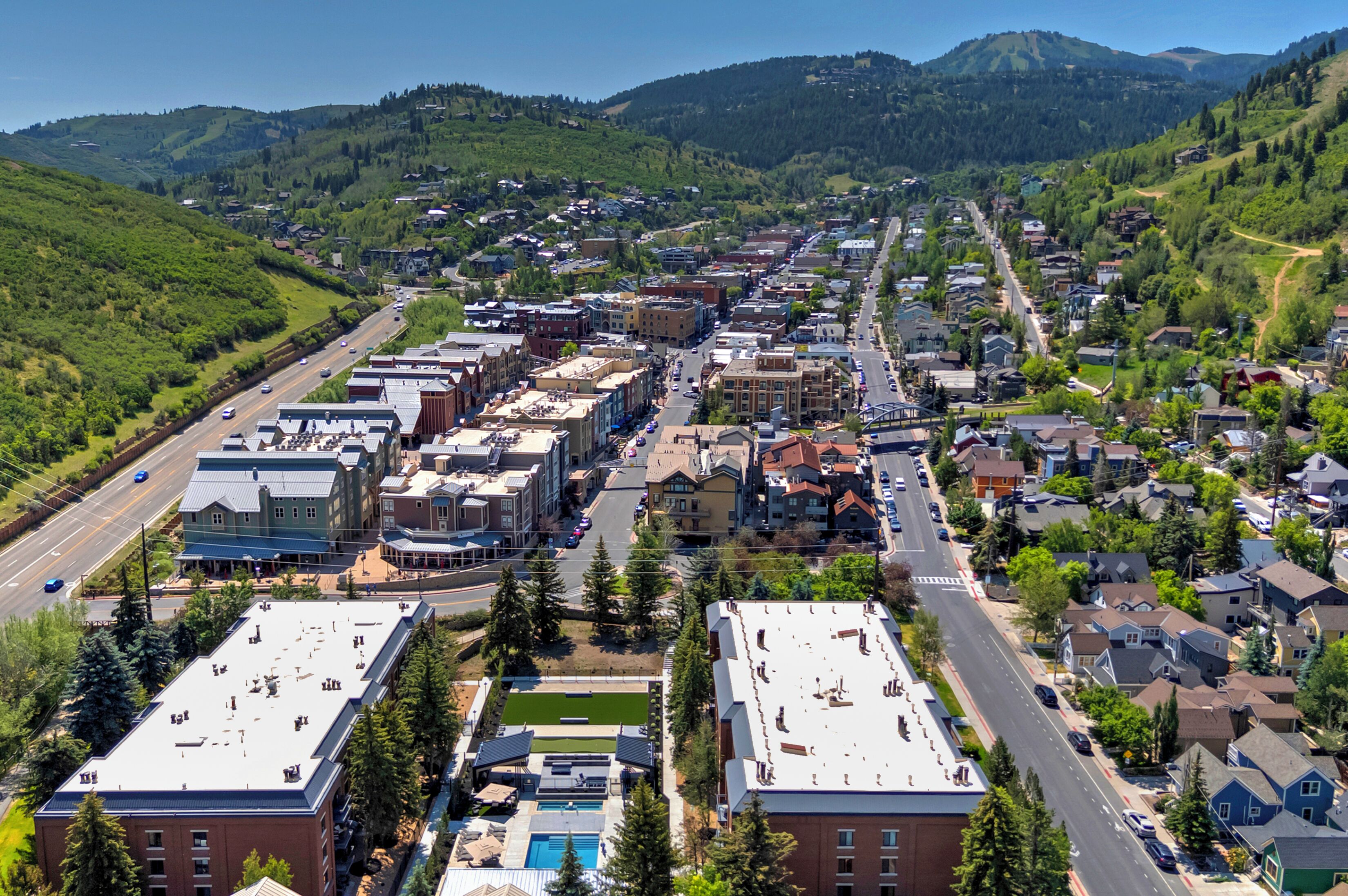 A town with a main street, buildings, and a hilly backdrop.