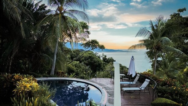 A pool area with a wooden deck, lounge chairs, and a view of the sea. - 4BR Oceanfront Luxury Villa • Private Estate • Spectacular Sunsets (Dominical)