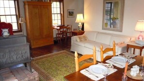 Un salón acogedor con chimenea, una mesa de comedor para cuatro personas y un sofá cómodo.
