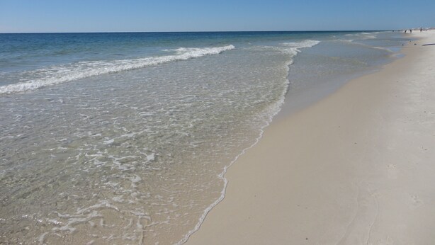 Una playa con agua cristalina y una orilla de arena.