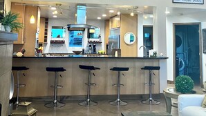 Une cuisine moderne avec un coin bar, un plafond haut et un balcon.