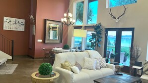 Un salon spacieux doté d’une grande fenêtre, d’une cheminée et d’un coin repas.