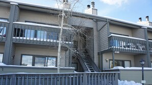 A multi-story residential building with balconies, a staircase, and a snow-covered ground. - Great family ski condo with access to all the Fraser valley has to offer (Fraser)