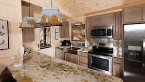 Una cocina moderna con armarios de madera, electrodomésticos de acero inoxidable y encimera de granito.