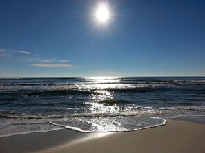 Uma praia com ondas e céu claro.